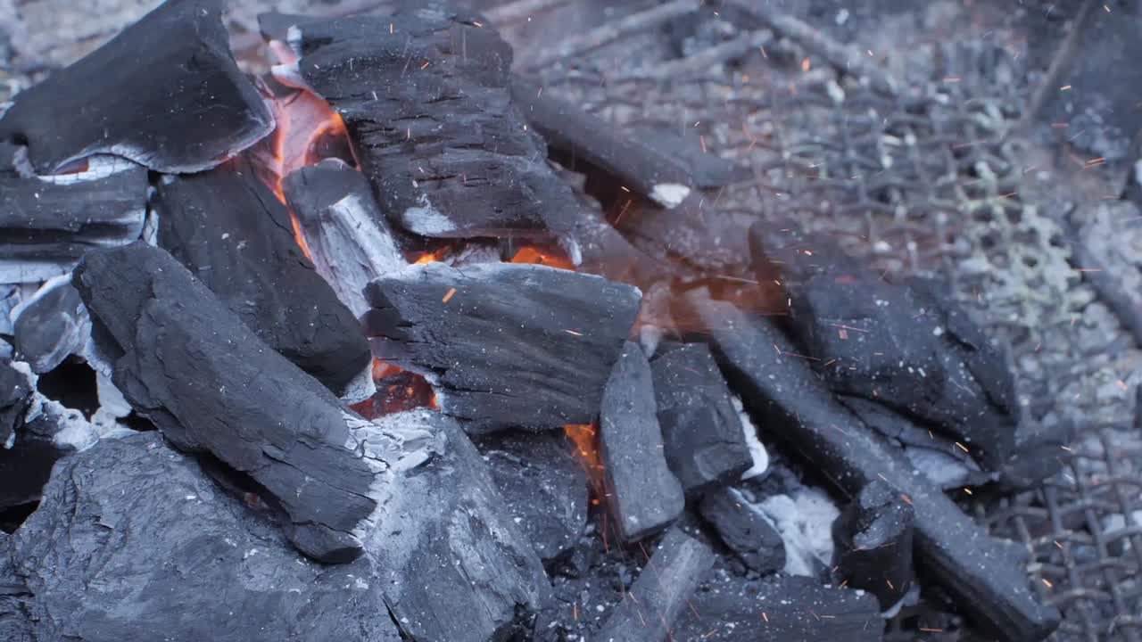 Hot coals on a barbecue while sparks fly