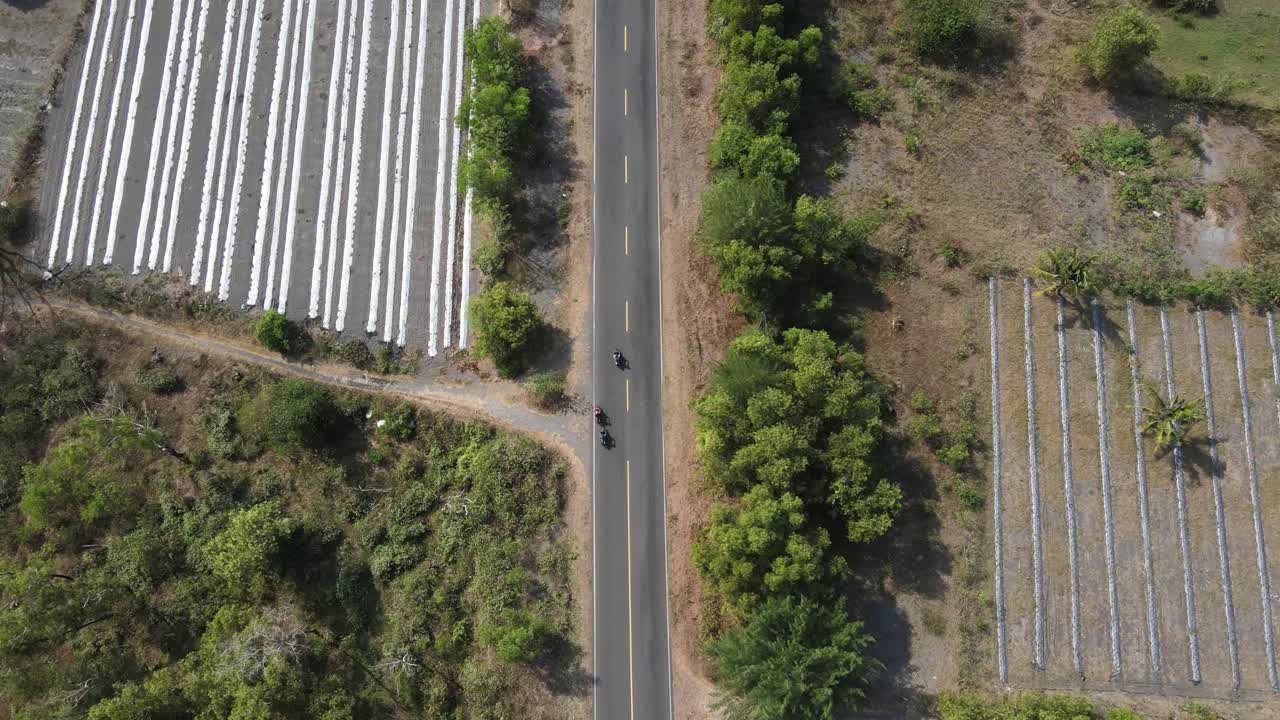 vista aérea, imágenes de drones siguiendo una motocicleta a toda velocidad a través del bosque de sabana en la costa sur de yogyakarta