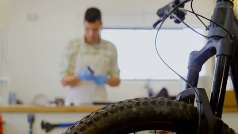 hombre limpiando piezas de bicicleta en el mostrador 4k