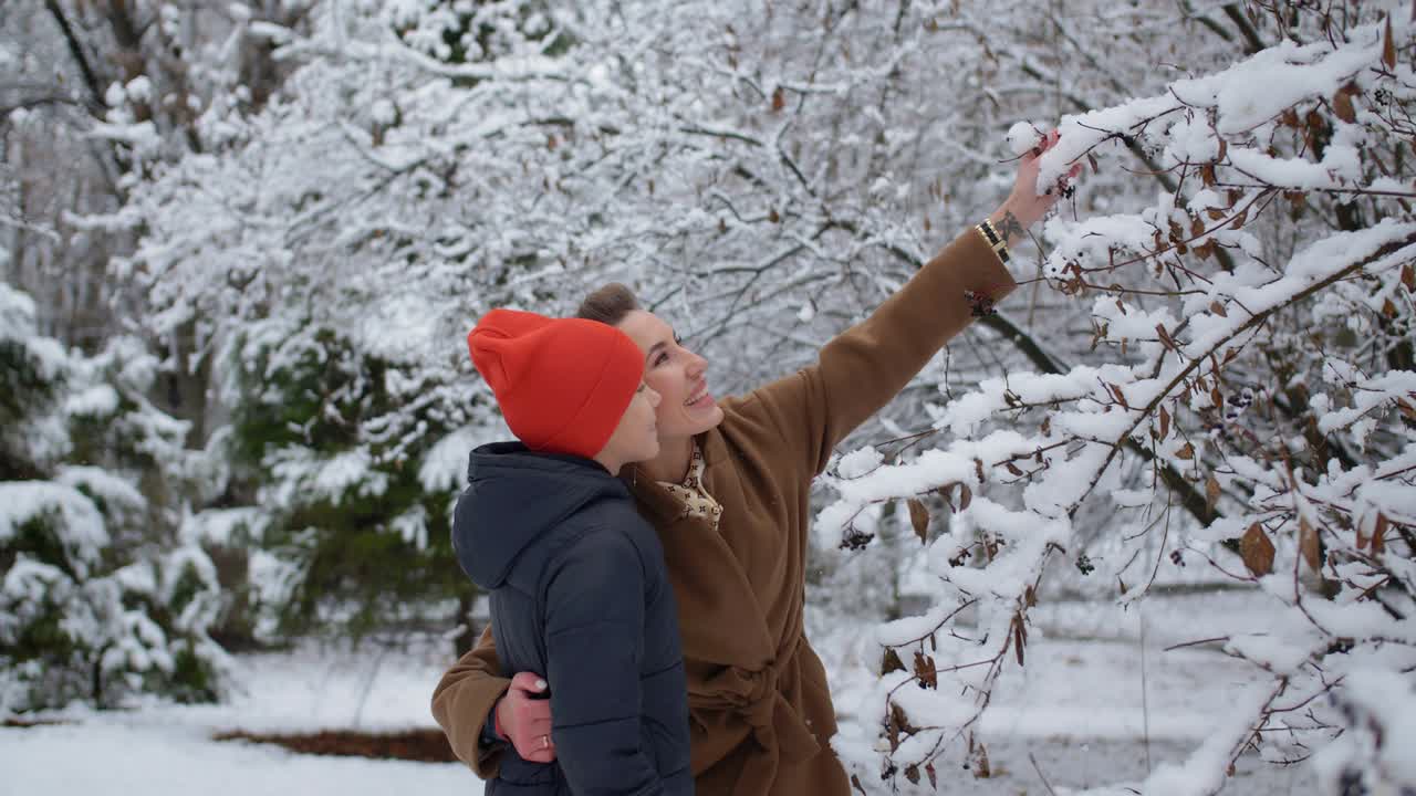 눈 인 공원에서 한 소년과 그의 어머니가 함께 재미를 느끼고 있습니다.