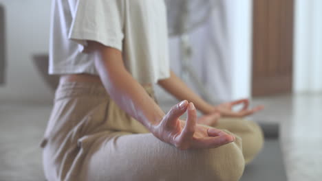 mujer meditando en una postura de yoga en casa