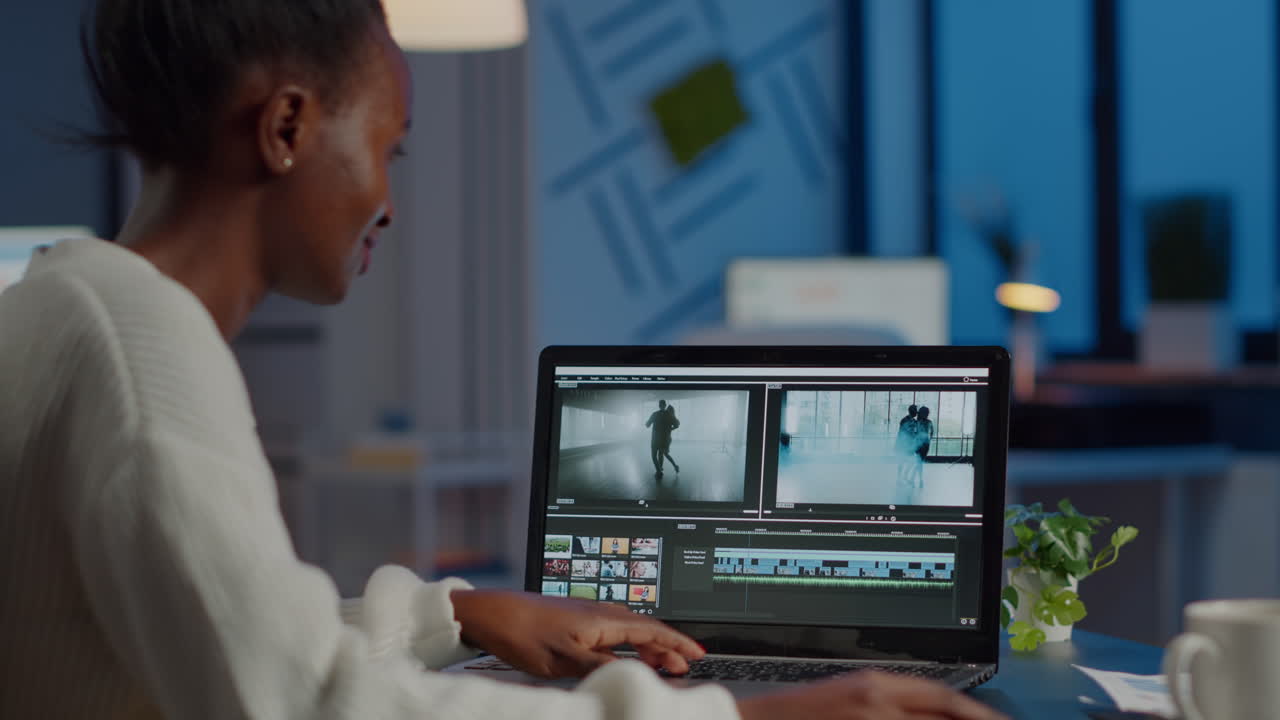 Videografer Afrika bekerja di laptop dari kantor mengedit proyek video.
