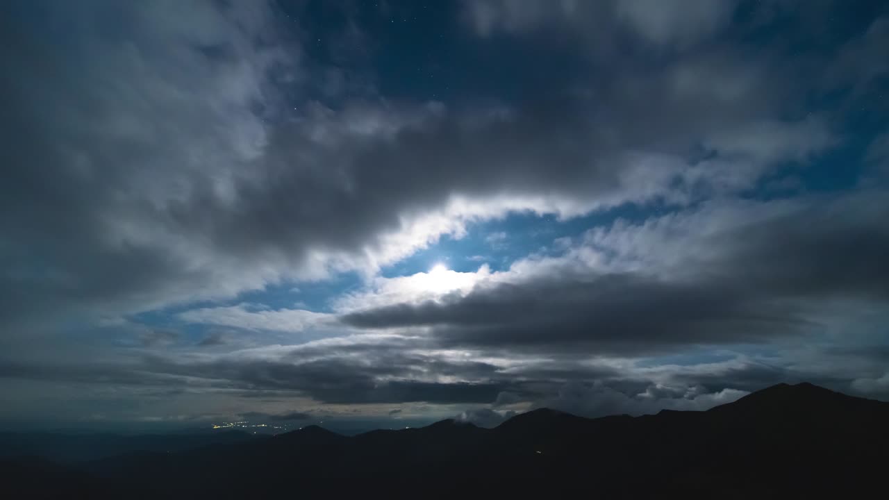 달빛 배경에 산 위의 구름 흐름. 시간 지연
