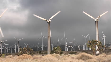 pan across windmill generating electrical power on a hillside in california