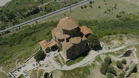 view from above of clifftop orthodox jvari monastery with overview of highway in mtskheta, georgia