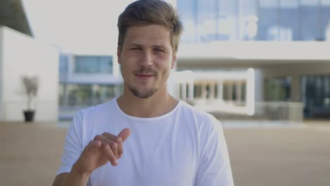 attractive bearded smiling man gesturing while talking to camera.