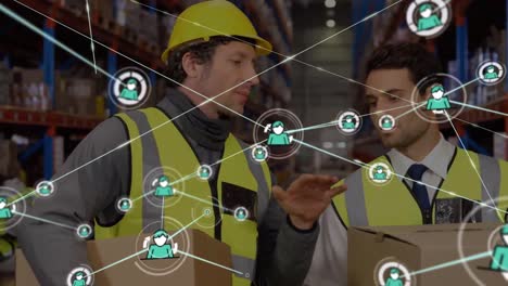 Animation-of-network-of-icons-over-caucasian-male-worker-and-supervisor-discussing-at-warehouse