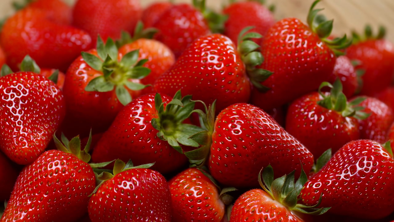 Macro Fresh Strawberries Piled On Wood, Glossy Red Berries With Green Calyx, Tight Composition Highlighting