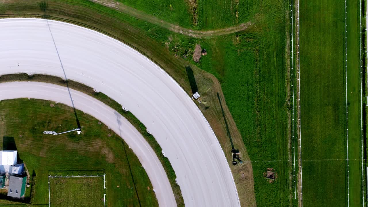 Top-down drone view of a Milan racecourse track, showing detailed layout, patterns, arena design