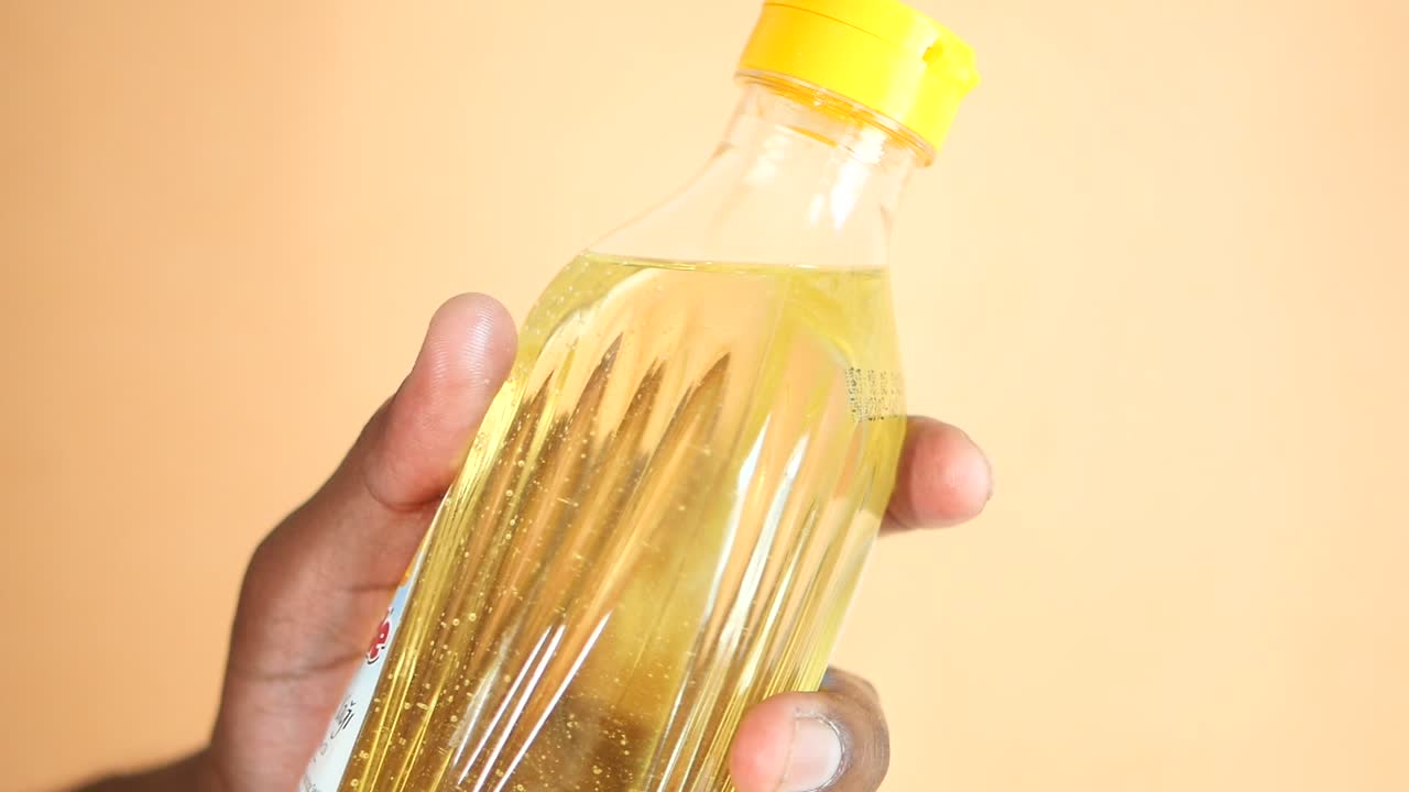 mano con una botella de aceite de cocina