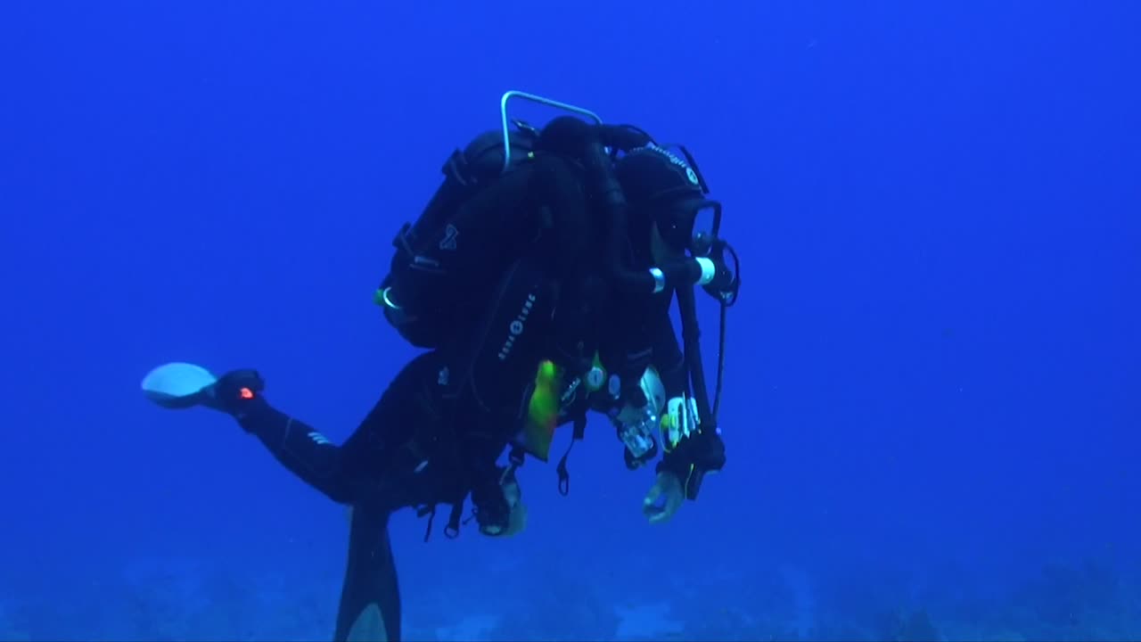 buzo técnico buceando en rebreather en las aguas azules profundas del mar rojo