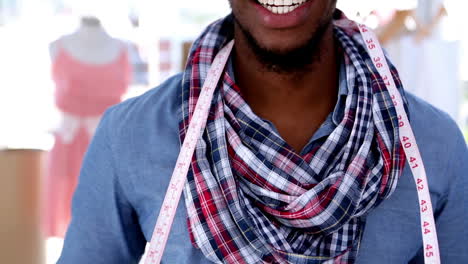 Happy-fashion-designer-hanging-a-measuring-tape-around-his-neck