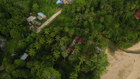 A-scenic-road-from-the-middle-of-the-palm-trees-parallel-to-the-coast-of-Koh-Lanta-near-Krabi-province,-Secluded-cottage-at-the-coast-of-Island,-Thailand