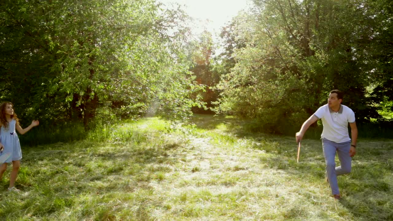 padre e hija jugando al bádminton en un parque