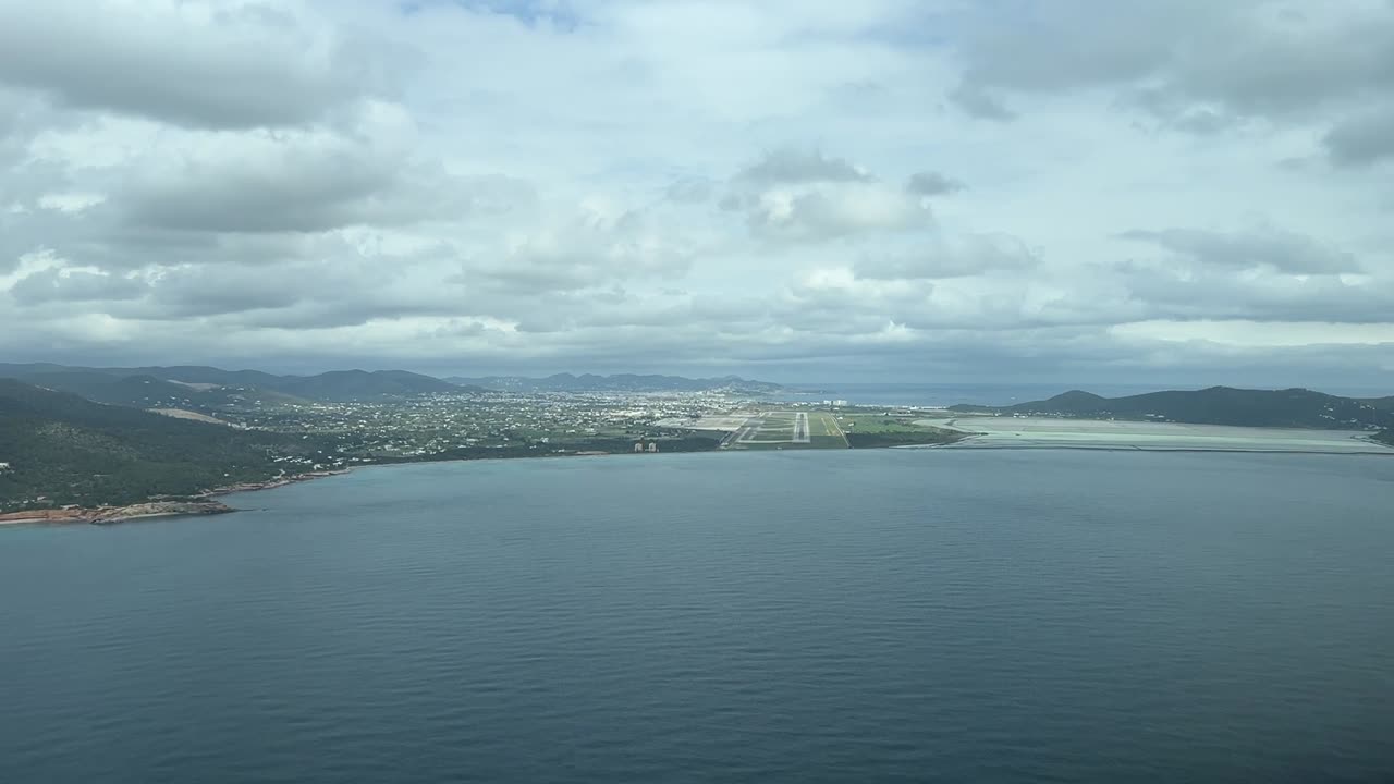 Cockpit view from a cockpit of Ibiza’s airport, Spain, with a scatterd cloudy sky from the sea