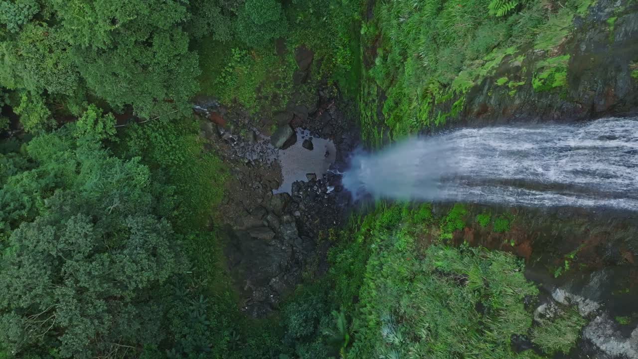 disparo de arriba hacia abajo de una cascada épica que se derrumba en la selva de la república dominicana - salto del rodeo, bonao