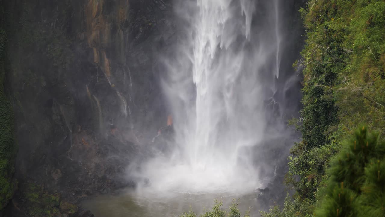 toma en cámara lenta de agua de la cascada sipiso piso en el norte de sumatra, indonesia golpeando el lago en el fondo