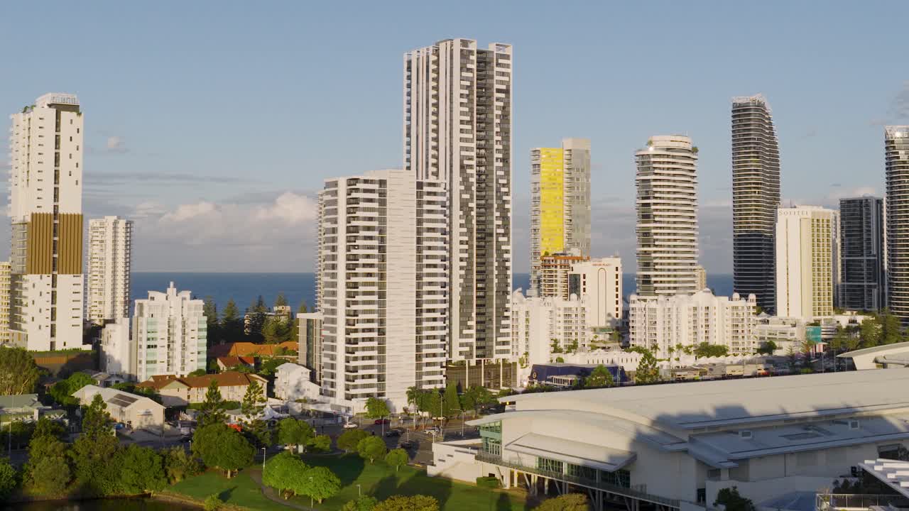 Drone footage captures Gold Coast's skyline with high-rise buildings during golden hour, highlighting urban development and coastal beauty