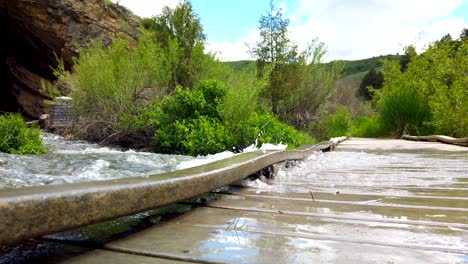 rushing water is seen over flowing onto a bridge