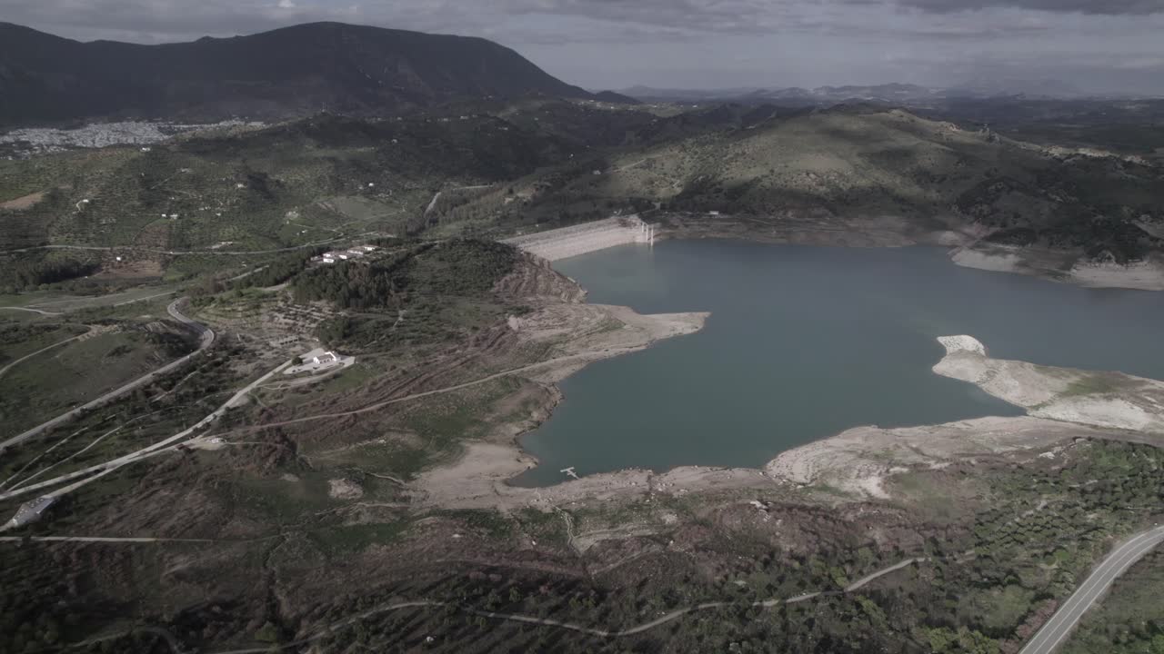 4K bird’s-eye drone shot of Zahara de la Sierra reservoir, Spain, filmed with a DJI at 30fps. A stunning aerial view capturing the tranquil waters and surrounding natural beauty.
