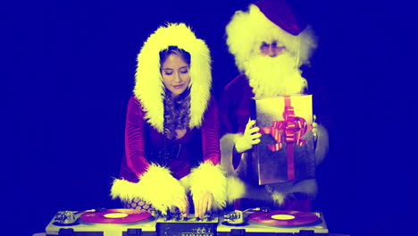 papá noel y la mujer con disfraces de navidad djing para la sesión de discoteca de navidad