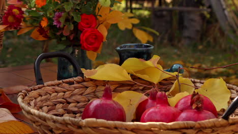 Mesa-De-Acción-De-Gracias-Con-Cestas-De-Nueces-Y-Granadas-Rojas-Maduras-En-La-Mesa-Del-Jardín