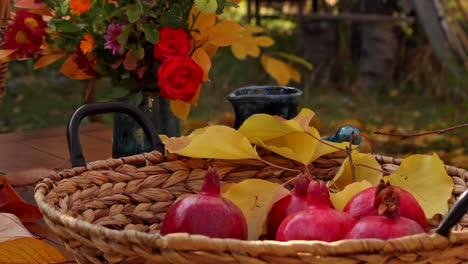 mesa de acción de gracias con cestas de nueces y granadas rojas maduras en la mesa del jardín