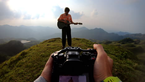 pov del tipo de la cámara disparando a un guitarrista, pov de mano