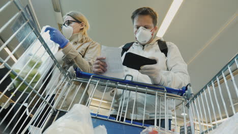 young couple buys fruit in supermarket during coronavirus epidemic