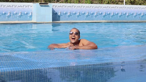 isolated young man swimming in pool with clear water at morning