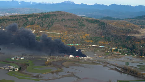 burning storage yard surrounded by flood plains in british columbia, canada