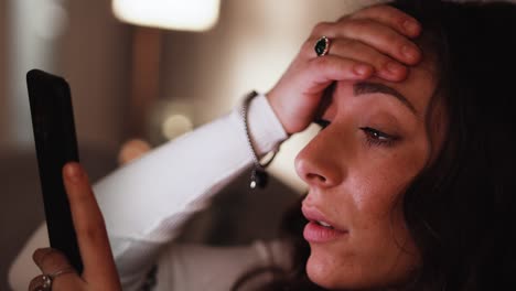 young italian put's her hand on her head out of shock while looking at her smart phone