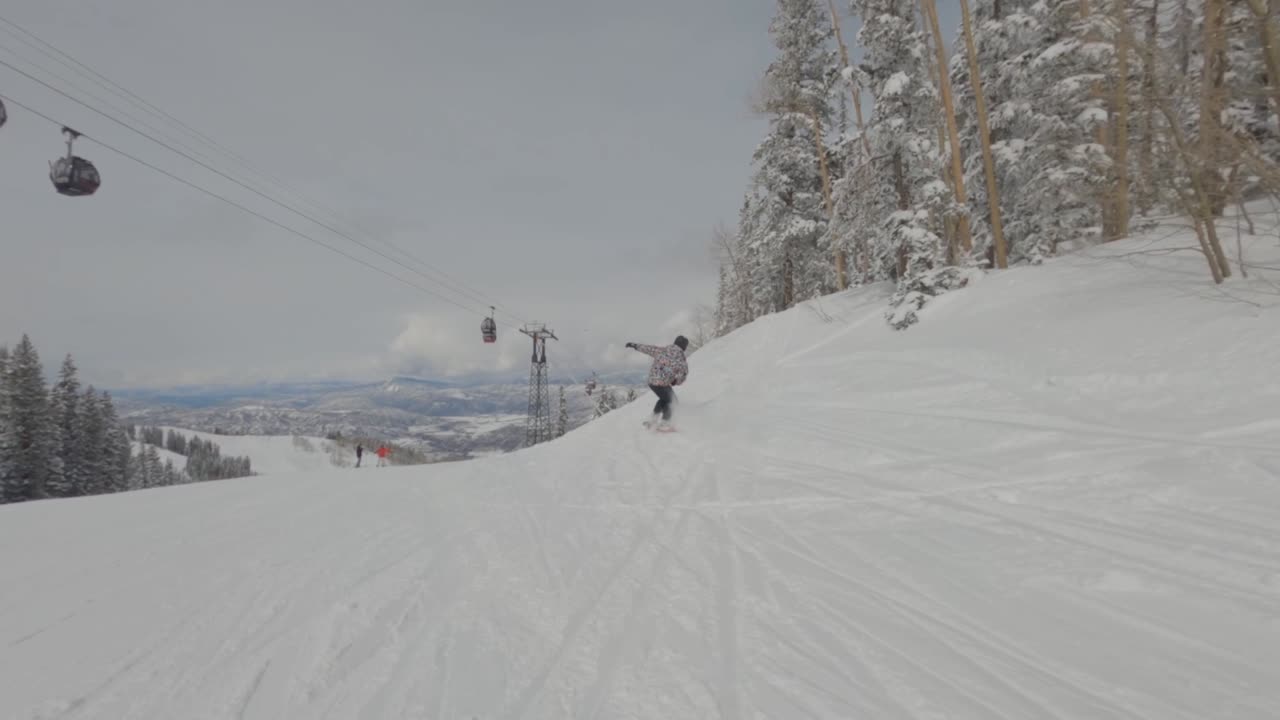 Man snowboarder riding down snow slope and fall down,  Aspen Colorado