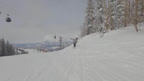 man snowboarder riding down snow slope and fall down,  aspen colorado