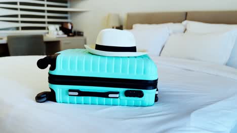 mint green suitcase on a hotel bed