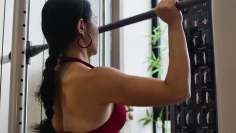 woman doing pull ups at the gym
