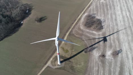 Molino-De-Viento-Disparado-Desde-Arriba-Con-Su-Sombra-En-Cámara-Lenta