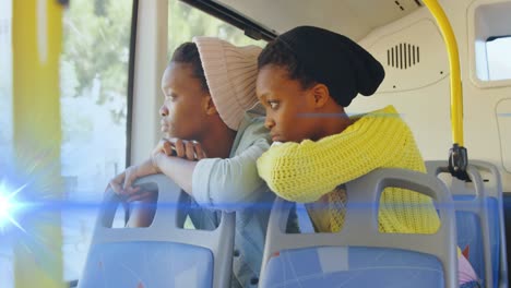 Animation-Eines-Blauen-Lichtstrahls-über-Zwei-Afroamerikanischen-Frauen-Im-Bus,-Die-Aus-Dem-Fenster-Schauen
