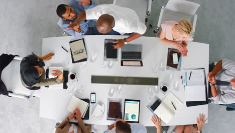 Business-people-high-five-in-meeting-at-work