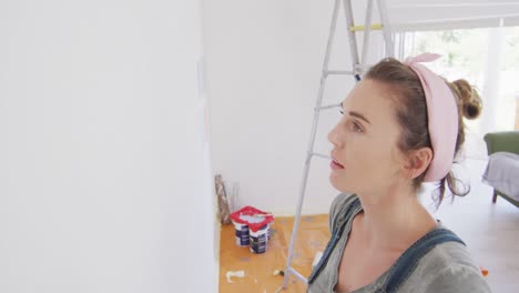 portrait of a caucasian woman in quarantine during coronavirus pandemic, doing interior work