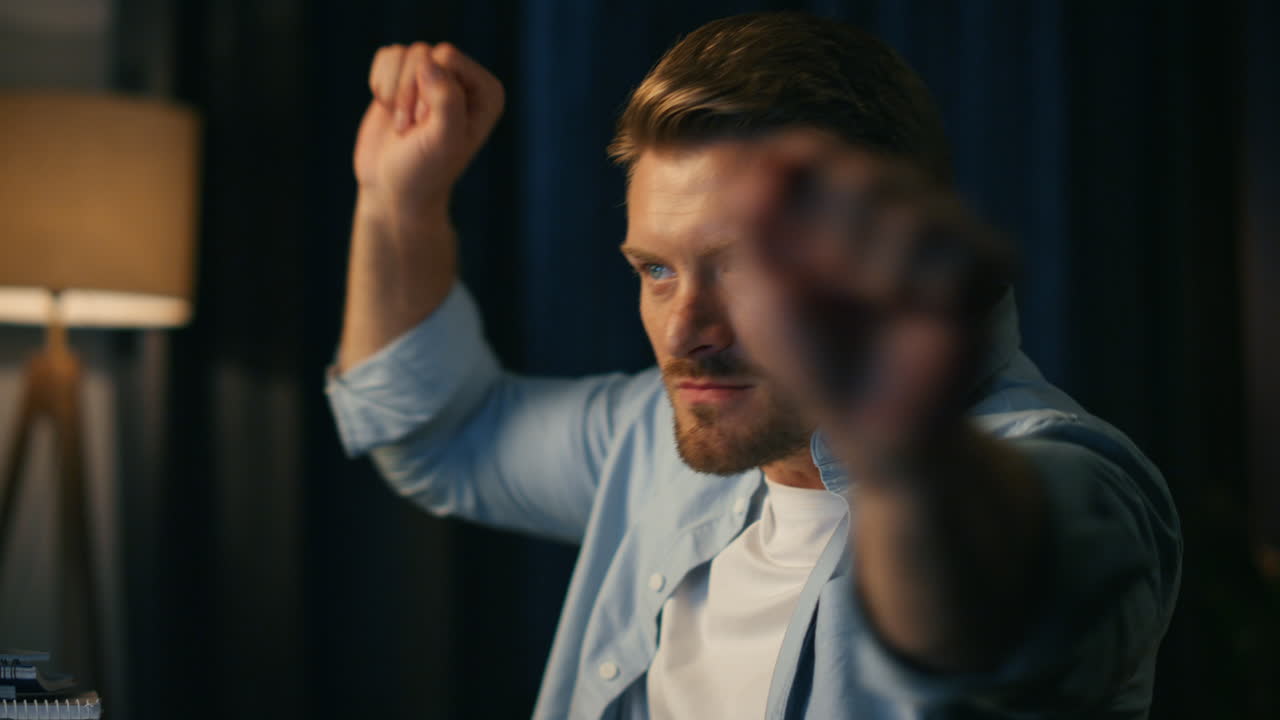 행복한 남자가 집에서 즐겁게 춤을 추고 긍정적 인 블로거가 승리를 축하합니다.