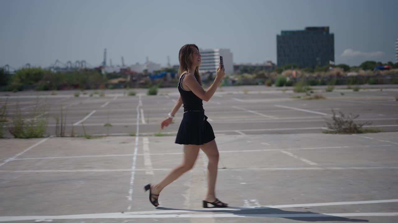 Woman walking in a parking lot with a phone
