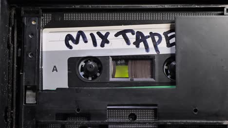 cassette tape. vintage tape recorder plays audio cassette tape inserted therein. zoom in.