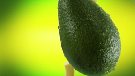 aguacate con rebanadas que caen sobre un fondo verde lima