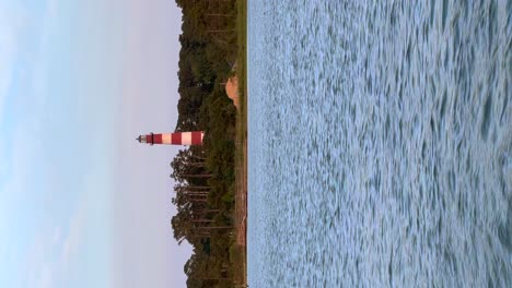 lighthouse on the water vertical video at sunset