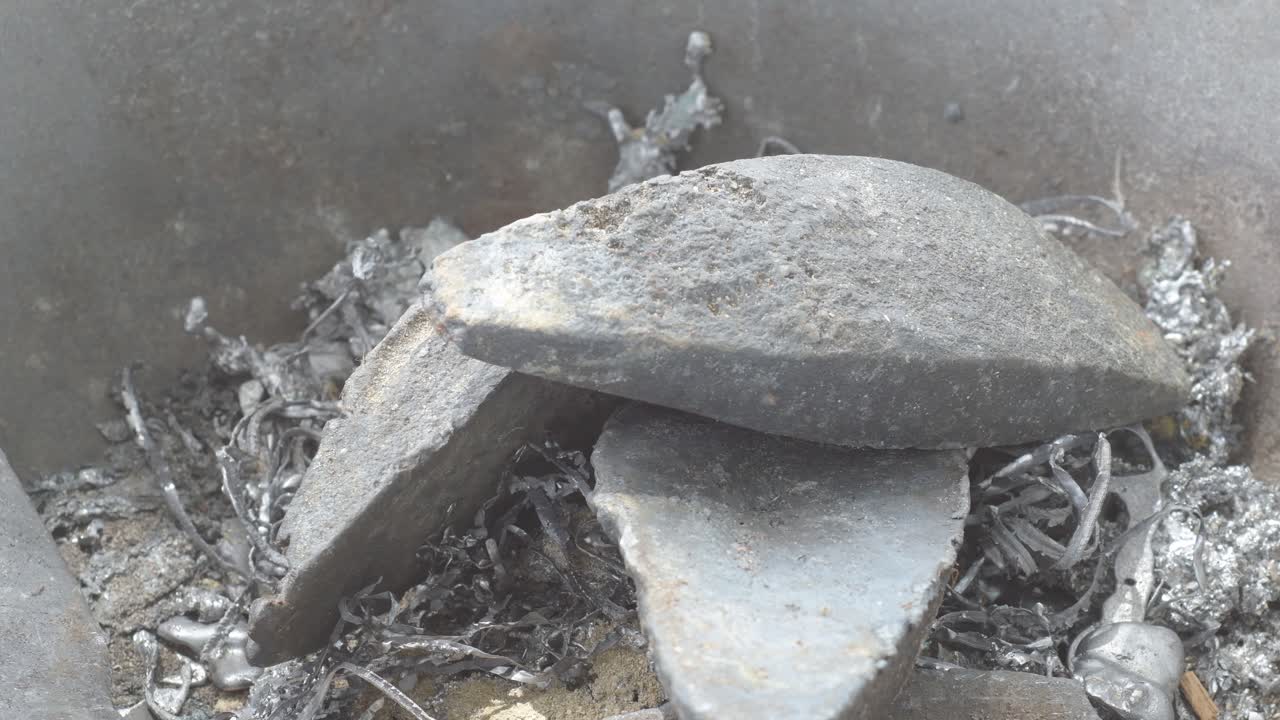 납 조각을 비에 넣고, 녹은 납 세부 사항, 금속 텍스처를 가게