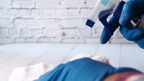 limpieza con botella de pulverización y guantes