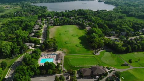 Umlaufende-Drohnenaufnahme-Einer-Driving-Range-In-Einem-Country-Club-Mit-Pro-Shop-Und-Swimmingpool