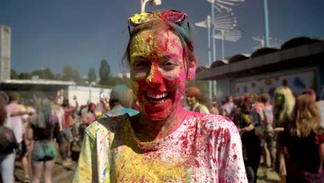 young happy girl in colourful powder is laughing on holi festival in daytime in summer, color concept