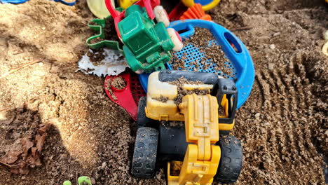 closeup of sandbox with colorful toy trucks and children toys